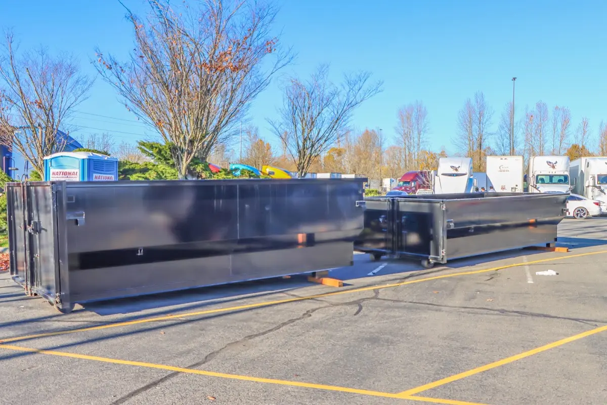 Professional dumpster rental service with roll-off container on residential driveway in Flat Rock